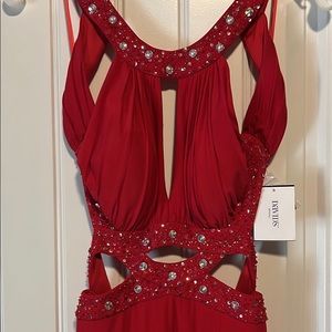 Long form fitting, slit skirt formal with cutout and tapered hem.